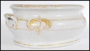 A 19th century Victorian large ceramic foot bath having shaped handles and gilded decoration.