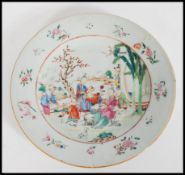 An 18th century Chinese porcelain plate hand enamelled and painted with scenes of figures in village