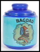 A vintage 20th century blue tobacco jar reading Bagdad, featuring a portrait of a middle eastern