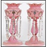 A pair of 19th century Victorian pink glass lustres with with crenelated rims, having seven