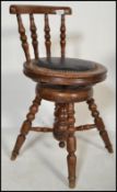 A 19th century mahogany artist revolving stool with turned spindle back having a studded seat.