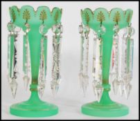 A pair of 19th century Victorian green glass lustres of trumpet form with with scallop detail
