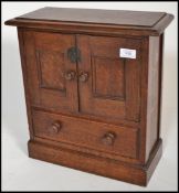 A Victorian carved oak smokers table top cabinet being raised on a plinth base with drawers and