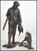 A bronze figure of a pheasant hunter with a hound and gun by Michael Simpson, stamped MS to the