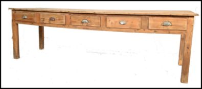 A large 19th century French country pine refectory dining table being raised on square tapering legs