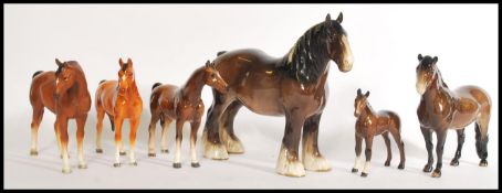 A group of ceramic horse figurines including a large shire horse ornament with smaller brown horse