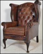 A vintage 20th century chesterfield style button back arm chair raised on mahogany cabriole legs
