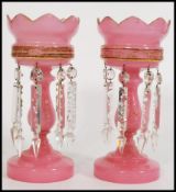 A pair of 19th century Victorian pink glass lustres with with crenelated rims, having seven