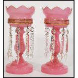 A pair of 19th century Victorian pink glass lustres with with crenelated rims, having seven