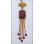 A vintage signed gold-tone drop necklace with large faceted purple glass stone with purple finial
