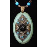 A 1930s Czech glass pendant necklace having turquoise glass and jet cabochon set pendant with barrel