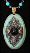 A 1930s Czech glass pendant necklace having turquoise glass and jet cabochon set pendant with barrel