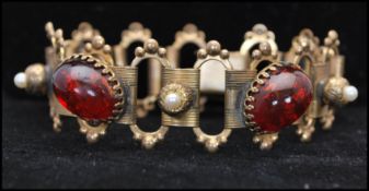 A 1920s Czech Art Deco bracelet set with red foiled glass cabochons and faux pearls. Measures 7