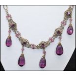 A 1920s Czech gold-tone filigree and amethyst glass drop necklace strung with large amethyst glass