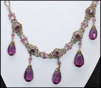 A 1920s Czech gold-tone filigree and amethyst glass drop necklace strung with large amethyst glass