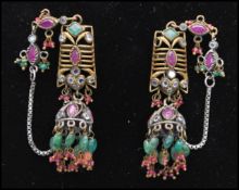 A pair of white and yellow metal vintage ruby and green stone tassel earrings. Measures 3 1/2