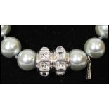 A signed Nour London grey pearl necklace having knotted strung faux pearls with magnetic