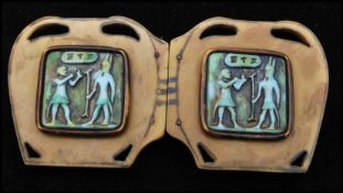 A 1920s large Art Deco Egyptian revival bakelite belt buckle having pierced cartouche with pictorial