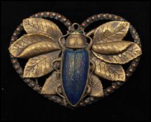 A 1930s Art Deco belt buckle set with an iridescent glass scarab beetle having rhinestone eyes