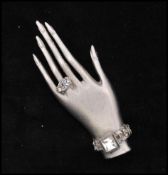 A 1980s signed Askew of London silver-tone brooch pin in the form of a graceful hand with jewelled