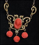 A 1930s Czech cameo necklace strung on a gold-tone chain having coral colour floral drops.