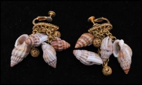 A pair of signed Miriam Haskell shell earrings having screw backs with shell and filigree drops.