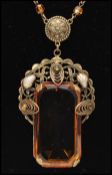 A 1920s Czech pendant necklace strung with filigree and moulded glass amber beads, having a large