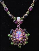 A 1920s faux opal suffragette necklace having a central faux opal surrounded by a halo of purple