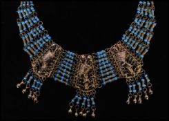 A vintage gold tone Egyptian style bib necklace with three large filigree work panels set with