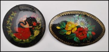 Two Russian lacquered hand painted brooch pins. One signed Mstera. Measures Approx 1.5 inches and