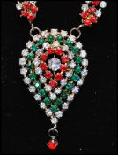 A 1970s Mogul style rhinestone necklace having red white and green rhinestones with a large