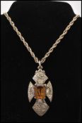 A signed mid 20th century Miracle necklace strung with an amber faceted glass crucifix cross