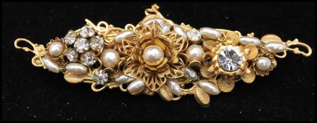 A signed  1950s Miriam Haskell Frank Hess gold-tone brooch having metal findings filigree work, faux