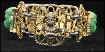 A 1960s Selro Selini style Asian faces gold-tone 5 link bracelet with clip clasp. Measures 7 3/4