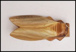 A 1920s French carved horn beetle cicada signed Cannes marked Deposé. Measures 2 inches.