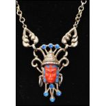 A 1950s Selro Selini Asian face necklace with coral colour asian head and blue rhinestones. Measures