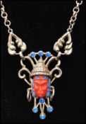 A 1950s Selro Selini Asian face necklace with coral colour asian head and blue rhinestones. Measures