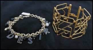 A signed Nina Ricci gold tone brand large link bracelet together with a Dolce and Gabbana charm