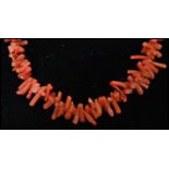 A vintage spezzati coral choker necklace having a yellow metal spring hoop clasp. Measures 15