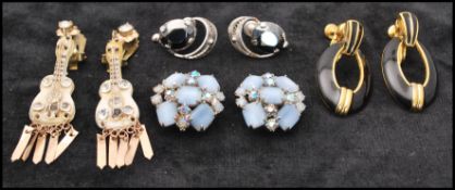 A collection of vintage clip on earrings some signed to include celluloid paste set guitars, satin