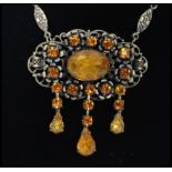 A 1930's Czech amber glass drop necklace having a decorative floral metal chain with large