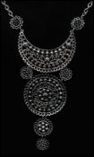 A 1970s white metal boho style filigree style necklace having four tiers and a clip fastener.