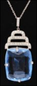 An Art Deco silver pendant necklace set with large blue glass stones and paste in a geometric
