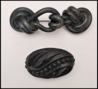 A circa 19th century Victorian vulcanite brooch together with a carved jet brooch. Largest