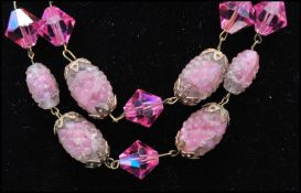 A vintage signed Trifari art glass pink sugar givre bumpy bead and crystal triple strand necklace.