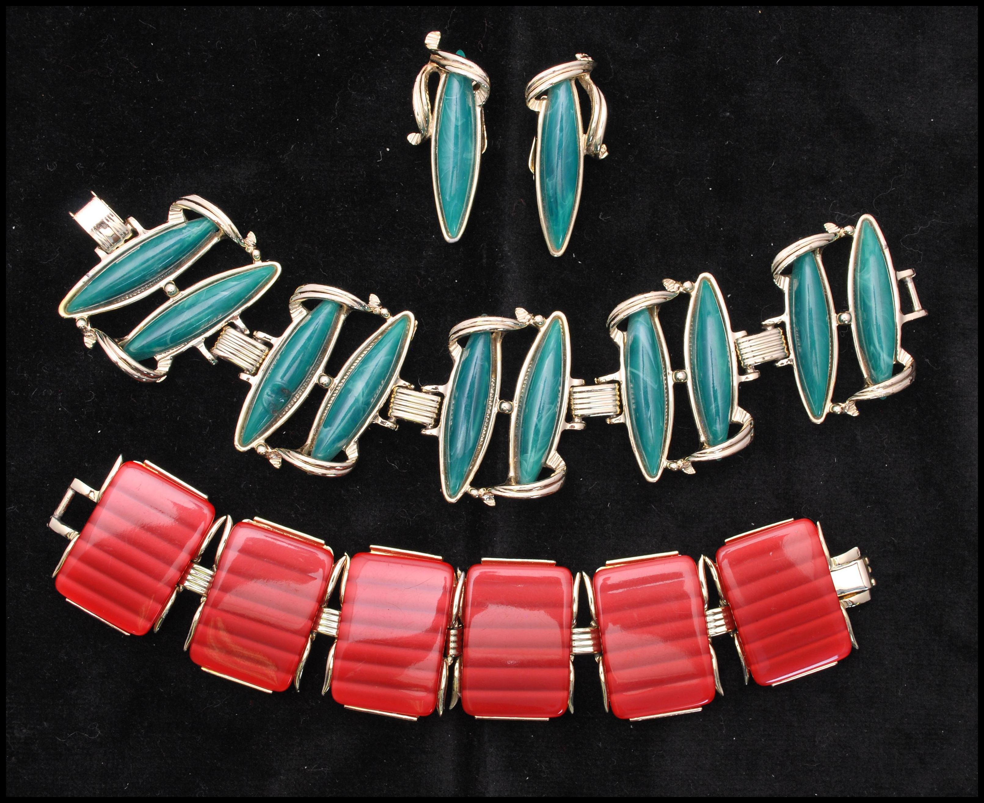 A 1950s gold-tone thermoset bracelet and earring set having green cabochons together with a 6 link