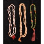 A collection of three ethnic tribal prayer bead necklaces to include a seed bead, a green glass