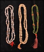 A collection of three ethnic tribal prayer bead necklaces to include a seed bead, a green glass