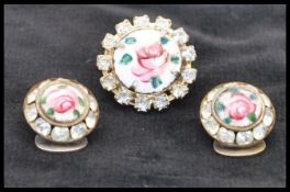 A vintage guilloche enamel brooch pin and clip on earring set having hand painted enamel roses on