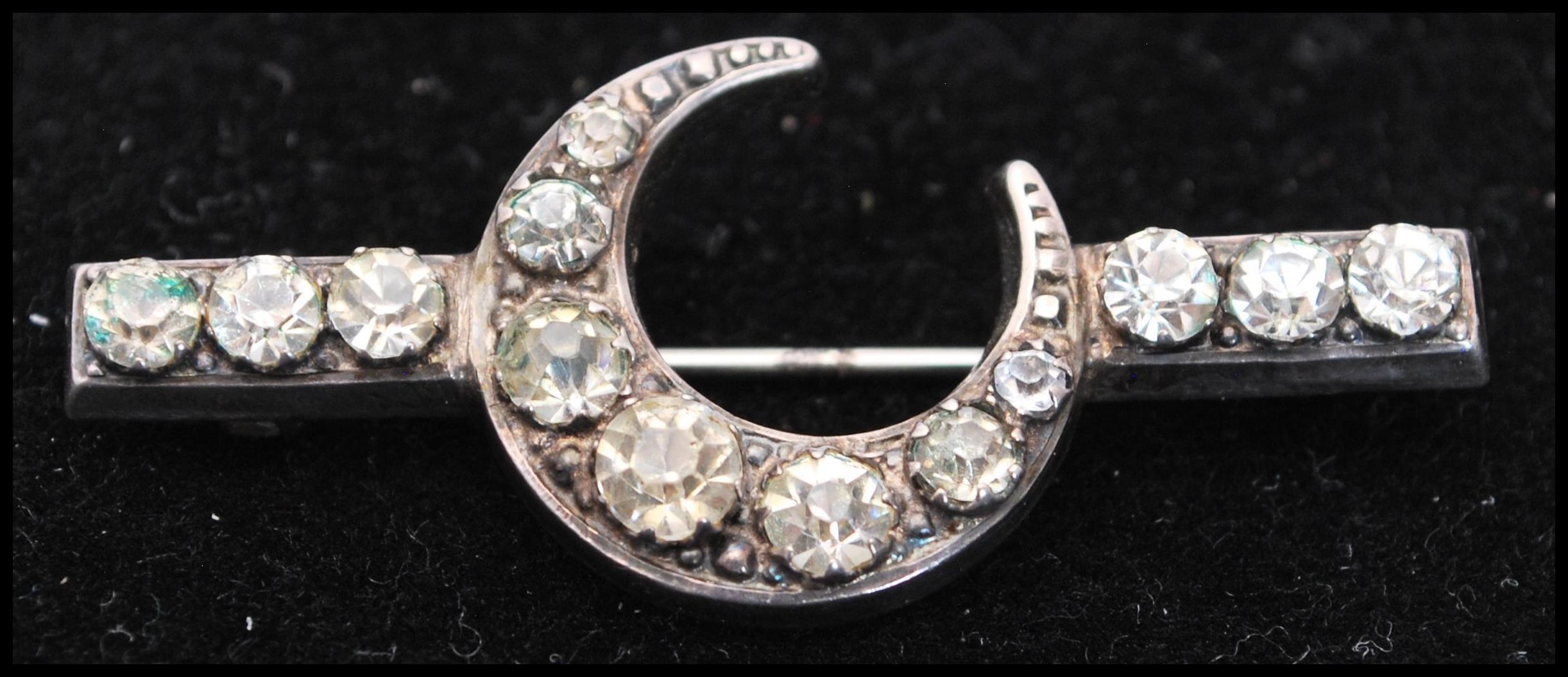 A hallmarked silver and paste brooch in the form of a crescent with c clasp. Hallmarked Chester,